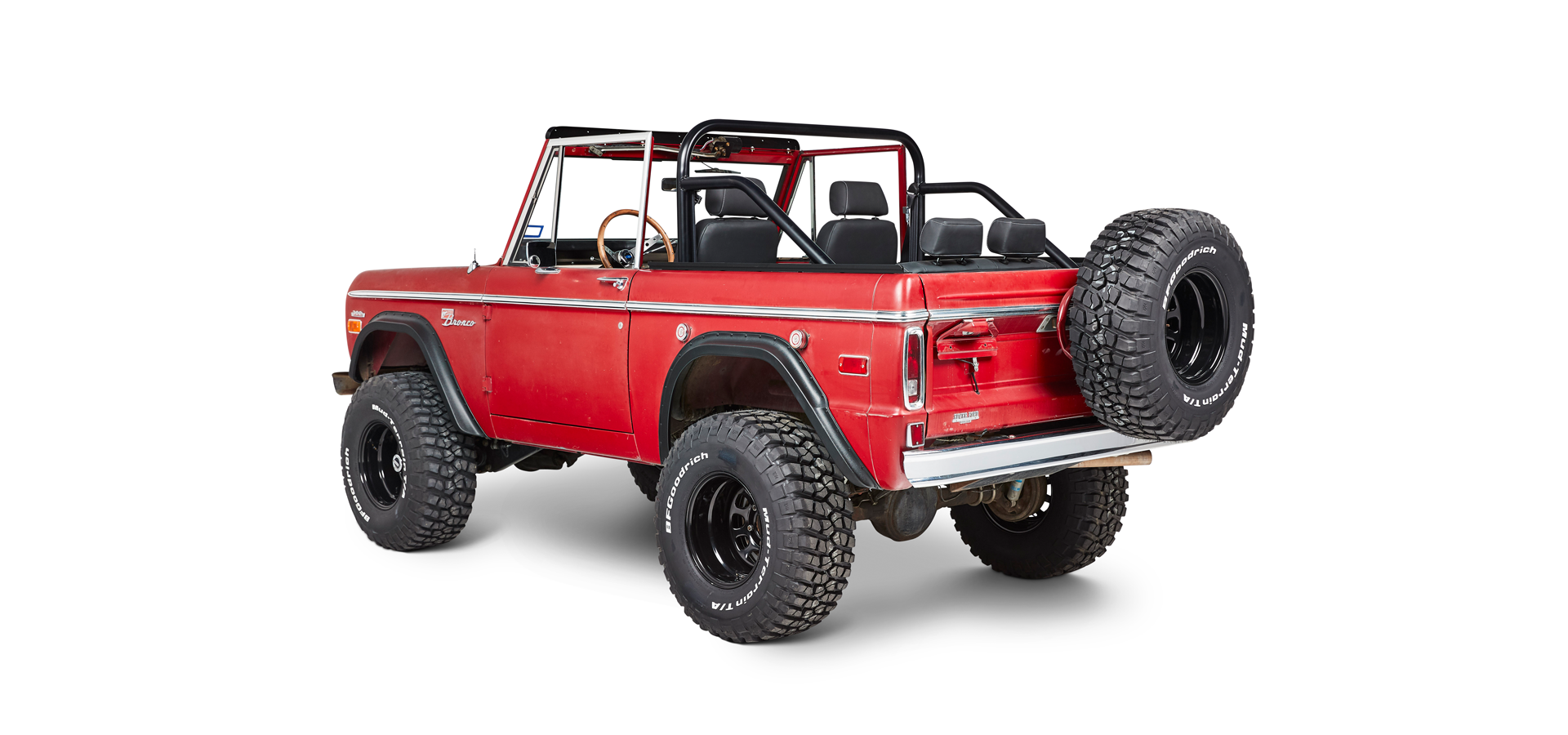Red Classic Ford Bronco angled rear view showing spare tire mounted on tailgate