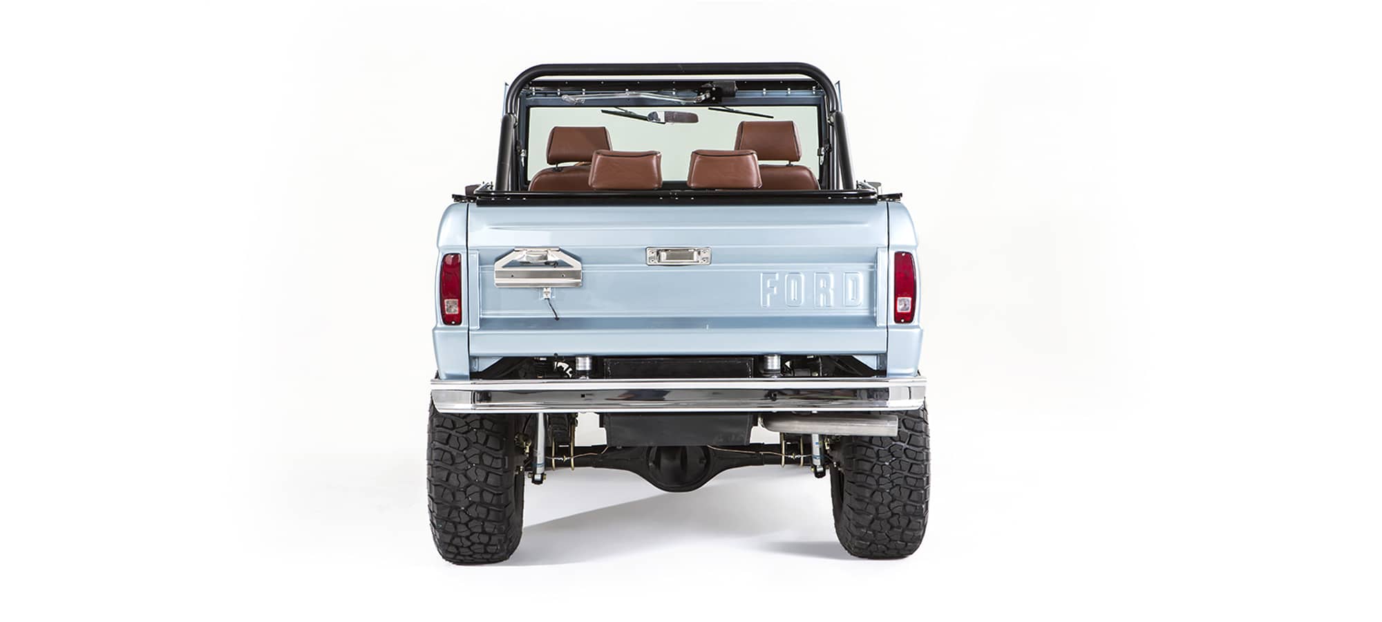 Rear view of light blue Classic Ford Bronco with exposed bumper and tires