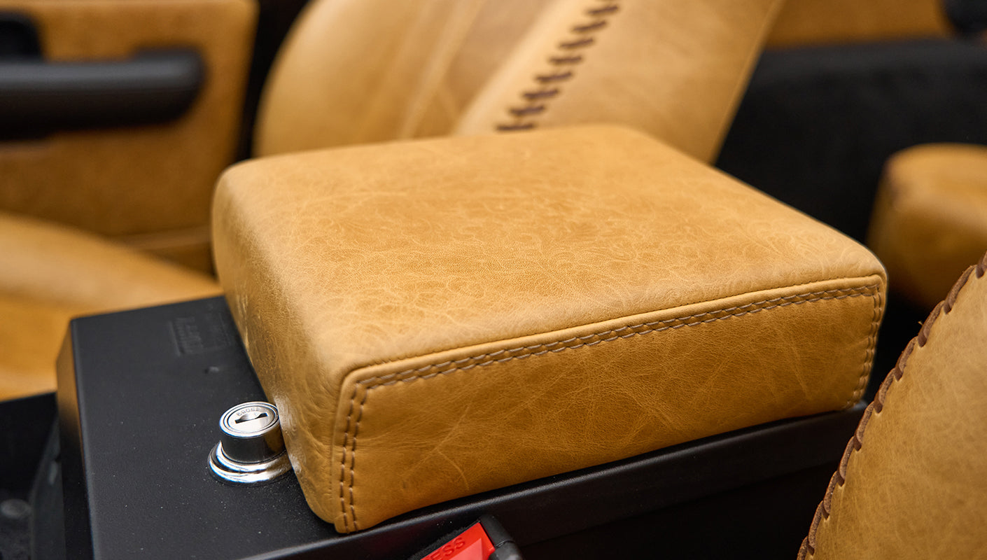 Close-up of tan leather armrest with black console and lock mechanism