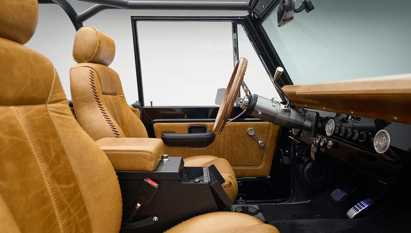 Interior front seats of Classic Ford Bronco with tan leather upholstery and center console