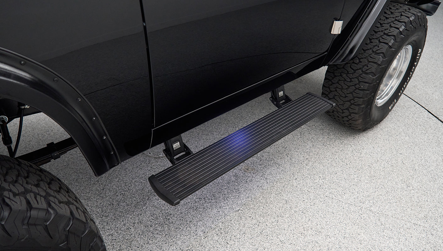 Black passenger side running board attached below Classic Ford Bronco door