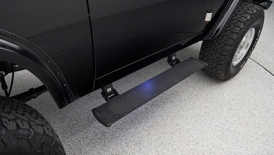 Black passenger side running board attached below Classic Ford Bronco door
