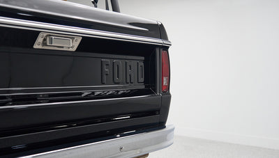 Rear tailgate of Classic Ford Bronco painted black with raised FORD lettering and red tail light