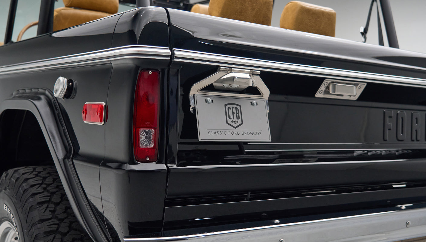 Rear side view of Classic Ford Bronco in black showing tail light and license plate area