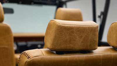 Close-up of tan leather headrest with embossed floral patterns on Classic Ford Bronco