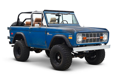 Three-quarter front view of Classic Ford Bronco with blue patina finish and open top