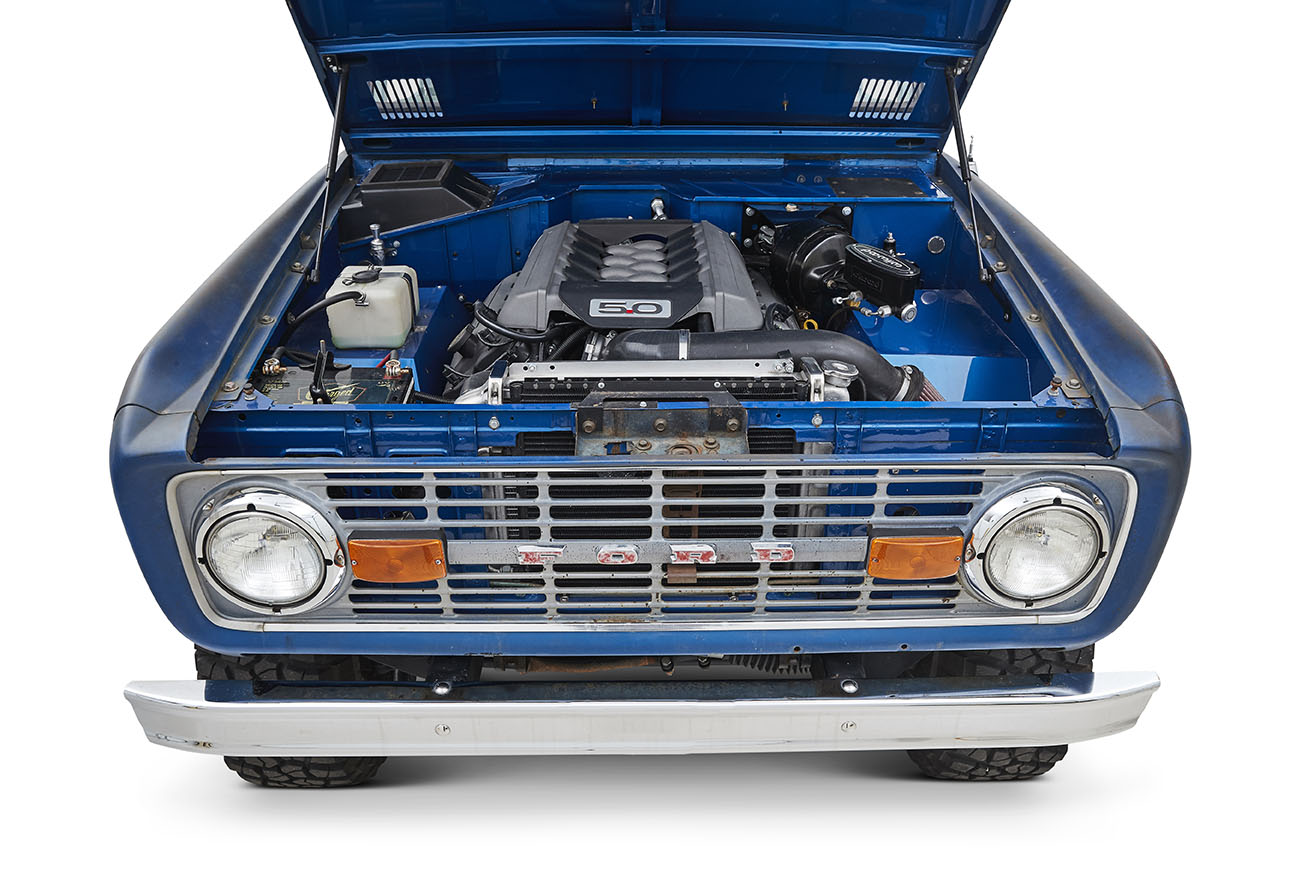 Head-on front view of a blue Classic Ford Bronco with chrome grille and round headlights