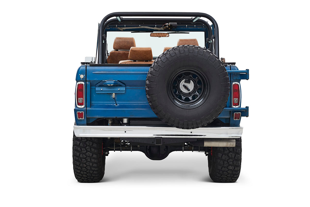 Rear view of blue Classic Ford Bronco with spare tire mounted on tailgate