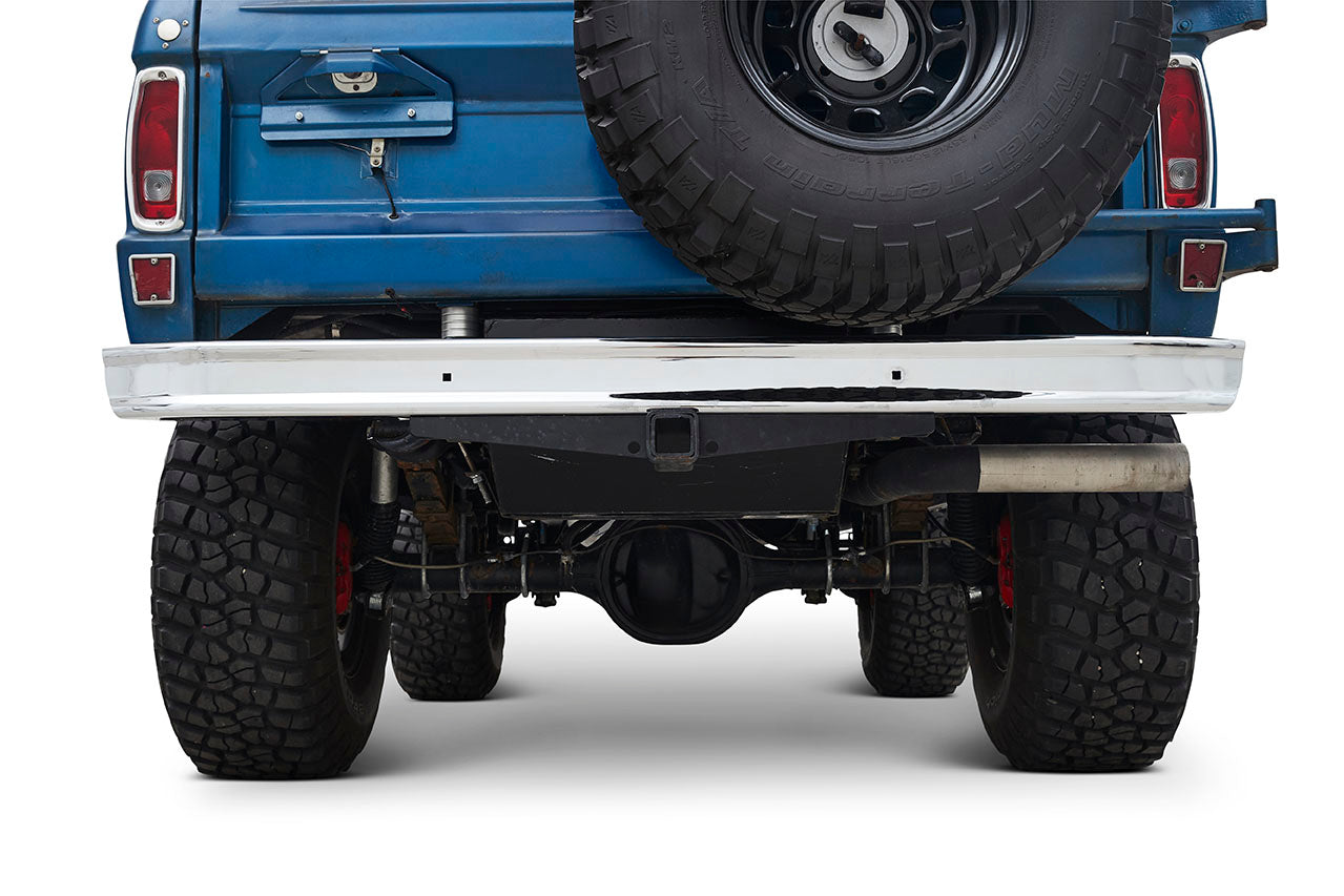 Rear view of a blue Classic Ford Bronco showing spare tire on the back and rugged tires underneath