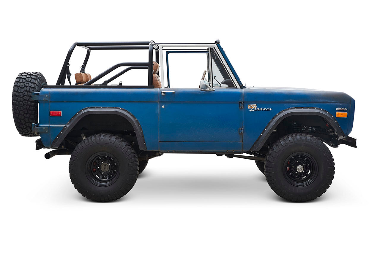 Side profile of blue Classic Ford Bronco with black fender flares and off-road tires