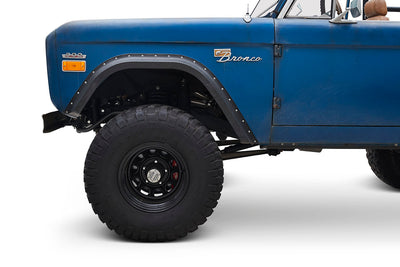 Close-up of front side wheel and door of Classic Ford Bronco with blue patina finish