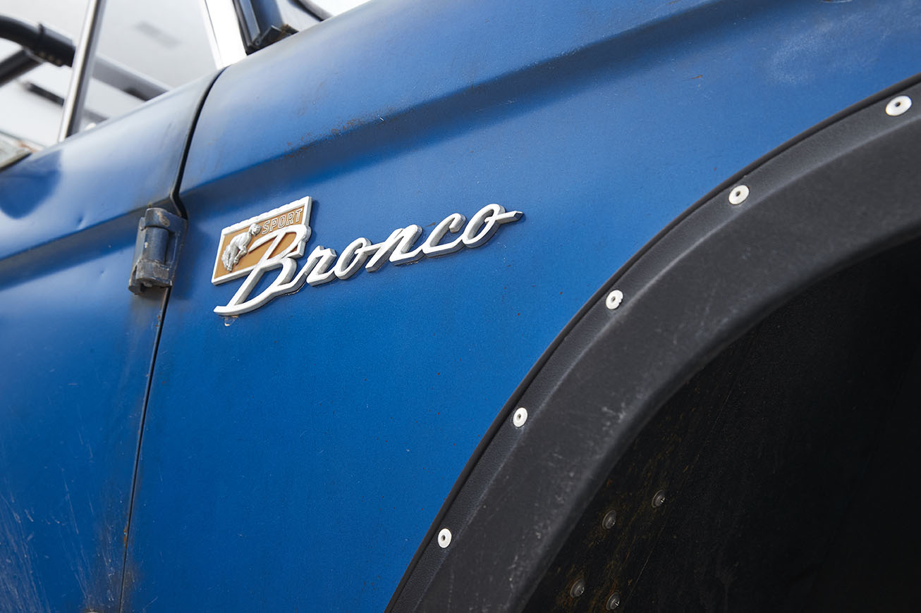 Close-up of blue Classic Ford Bronco door with bronze Sport Bronco emblem