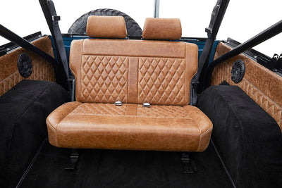 Brown leather rear bench seat with diamond pattern stitching inside a Classic Ford Bronco