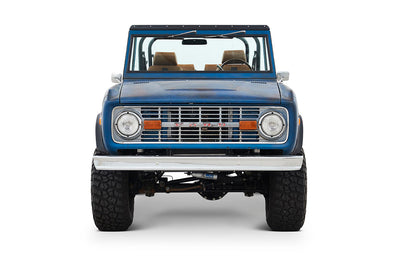 Front view of Classic Ford Bronco with round headlights and blue patina body
