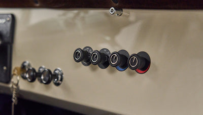 Close-up of classic vehicle dashboard knobs with black textured grips and colored markings
