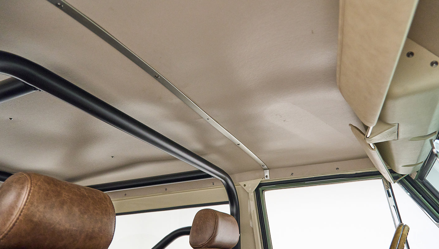 Light-colored headliner and upper interior frame with roll cage bars inside Classic Ford Bronco