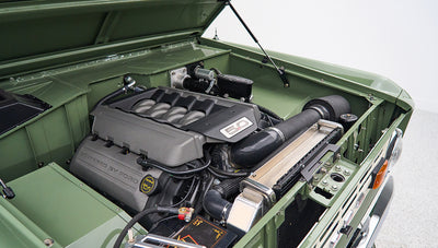 Engine bay of Classic Ford Bronco showing 5.0 liter Ford engine with green painted body
