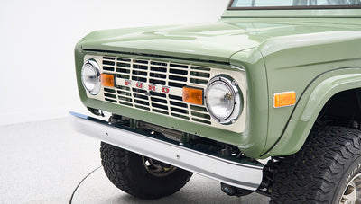 Classic Ford Bronco in boxwood green with white roof, rear view centered on white background.