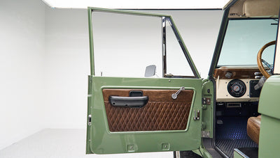 Open green and brown quilted leather door panel of Classic Ford Bronco in studio setting