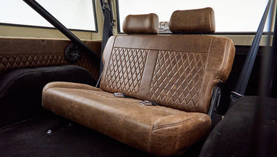 Brown leather rear bench seat with diamond stitching and seat belts in Classic Ford Bronco