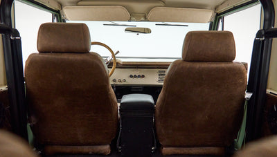 Rear view of Classic Ford Bronco front seats with textured brown leather upholstery and roll bar