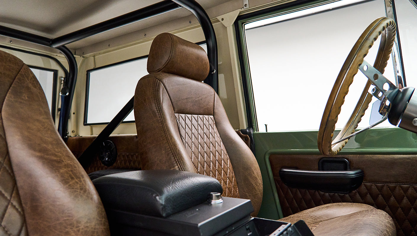 Classic Ford Bronco interior showing passenger seat with diamond pattern leather upholstery and center console