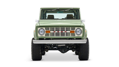 Classic Ford Bronco in boxwood green with white roof, front profile on white backdrop.