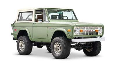 Front side view of a Classic Ford Bronco in boxwood green with white roof and chrome details