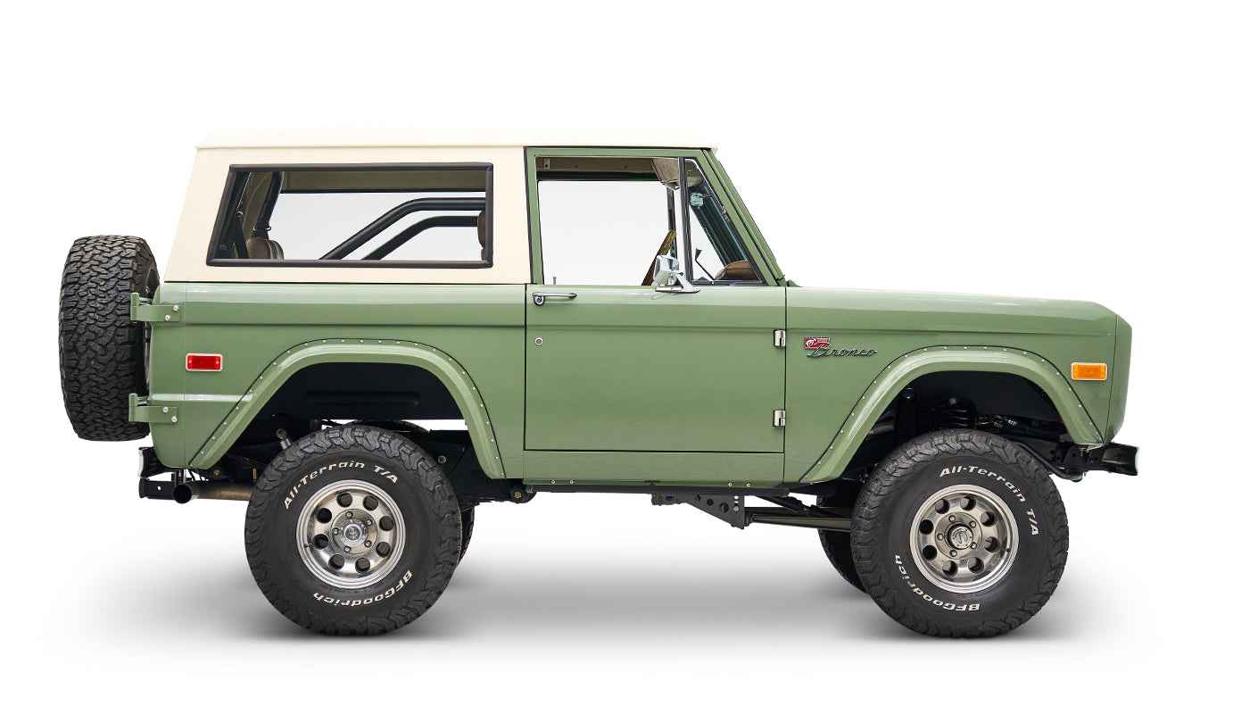 Classic Ford Bronco in boxwood green with white roof, side profile facing right on white backdrop.