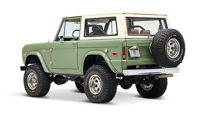 Classic Ford Bronco in boxwood green with white roof, angled rear view on white background.