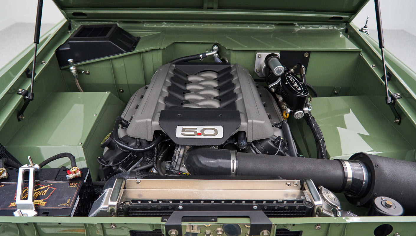 Close-up of 5.0 liter Ford engine and components inside green engine bay of Classic Ford Bronco
