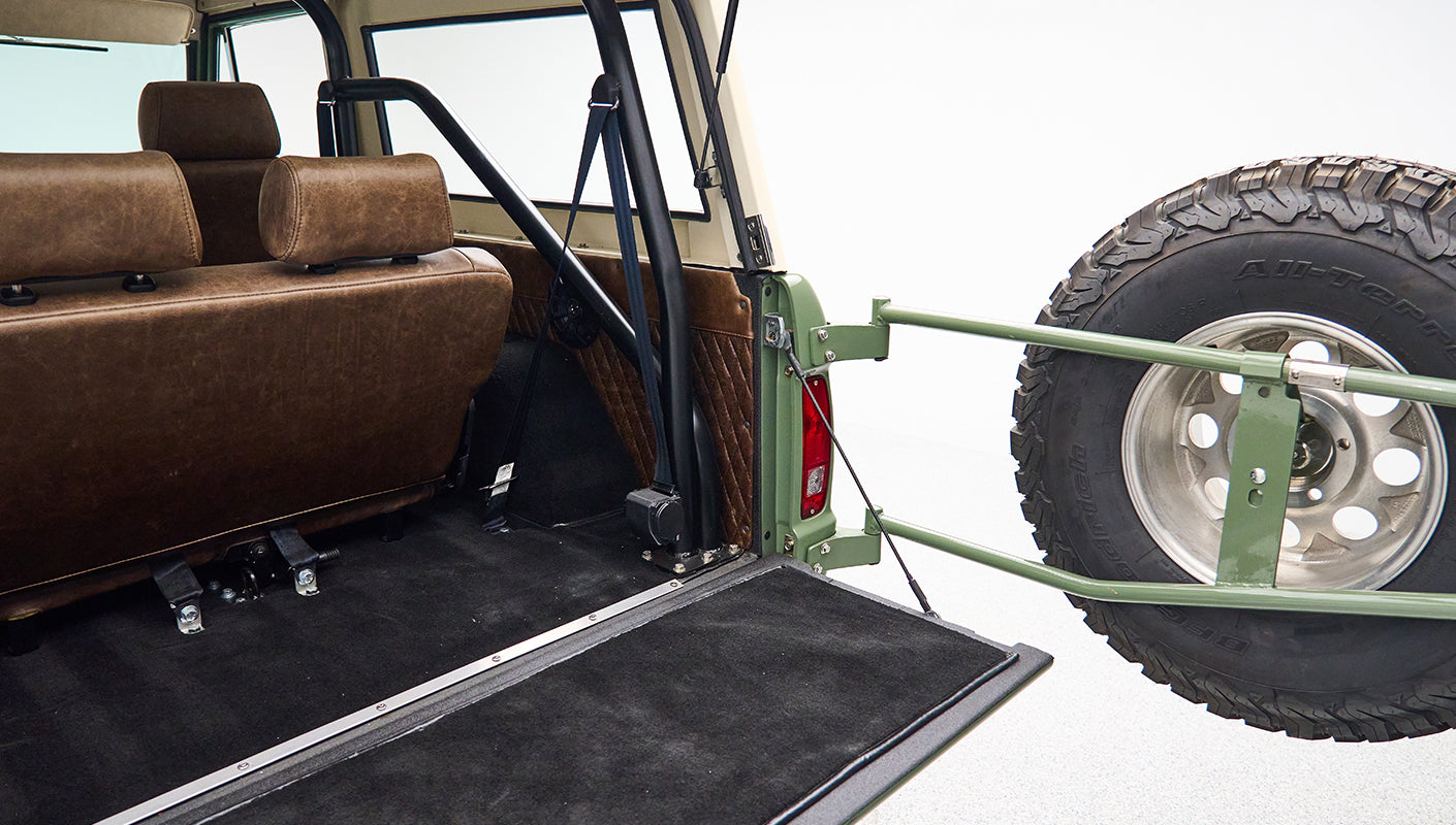 Open rear cargo area of Classic Ford Bronco showing spare tire mounted on tailgate