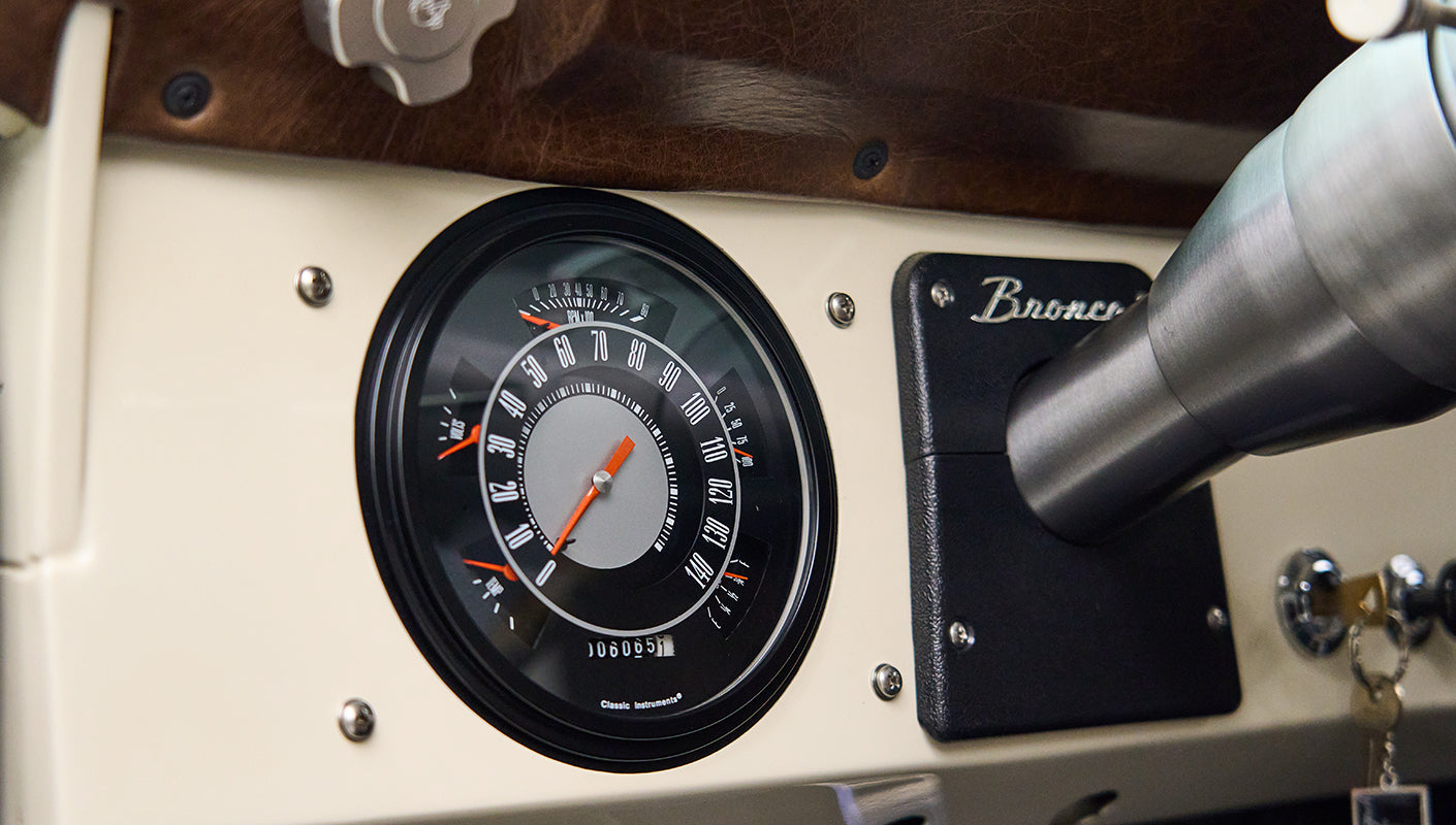 Classic Ford Bronco speedometer reading zero with black and silver face on dashboard