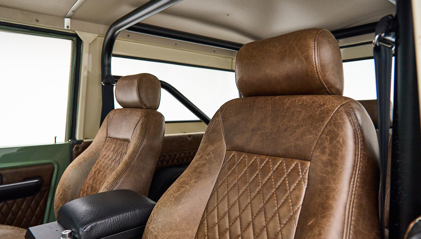 Brown leather front seats with diamond stitching and roll cage inside Classic Ford Bronco