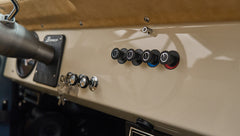 Classic Ford Bronco dashboard with vintage knobs and beige upholstery