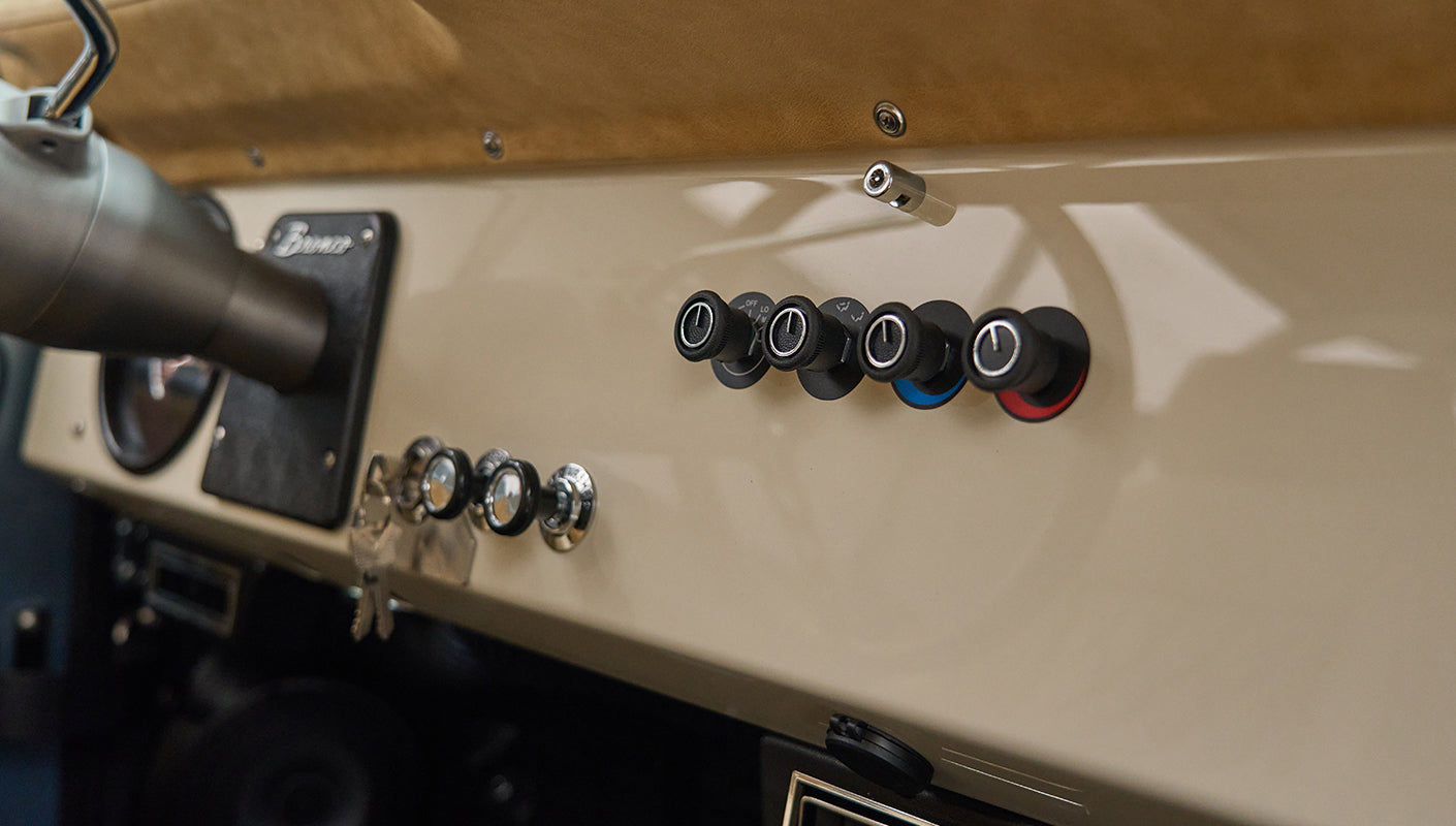 Classic Ford Bronco dashboard with vintage knobs and beige upholstery