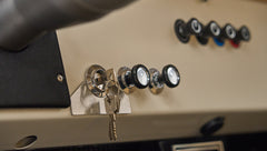 Ignition switch with key inserted and three black control knobs on Classic Ford Bronco dashboard.