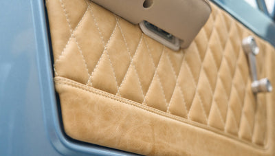 Close-up of beige diamond-stitched upholstery on door panel in Classic Ford Bronco.