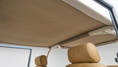Interior view showing beige soft top and roll cage frame above front seats of Classic Ford Bronco