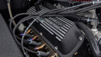 Close-up of black Bronco branded valve cover and spark plug wires inside Classic Ford Bronco engine