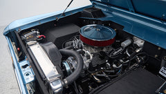 Close-up view of a Classic Ford Bronco engine with visible hoses, air filter, and radiator