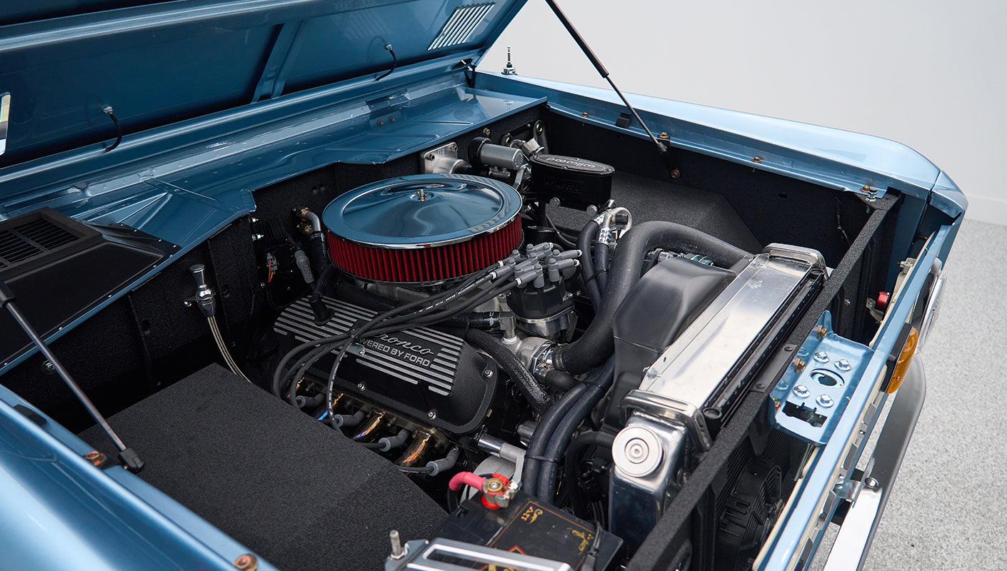 Engine compartment of Classic Ford Bronco showing detailed clean engine and components