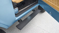 Metal black side step extended from open door on light blue Classic Ford Bronco
