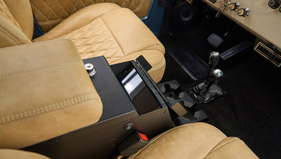 Console compartment open between tan seats inside Classic Ford Bronco