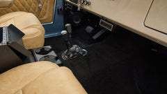 Front interior floor area of Classic Ford Bronco with two gear shifters and tan seats