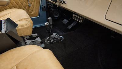 Front interior floor area of Classic Ford Bronco with two gear shifters and tan seats