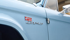 Close-up of Classic Ford Bronco badge on light blue door panel