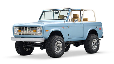 Light blue Classic Ford Bronco with tan interior and white roll cage, three-quarter right front view