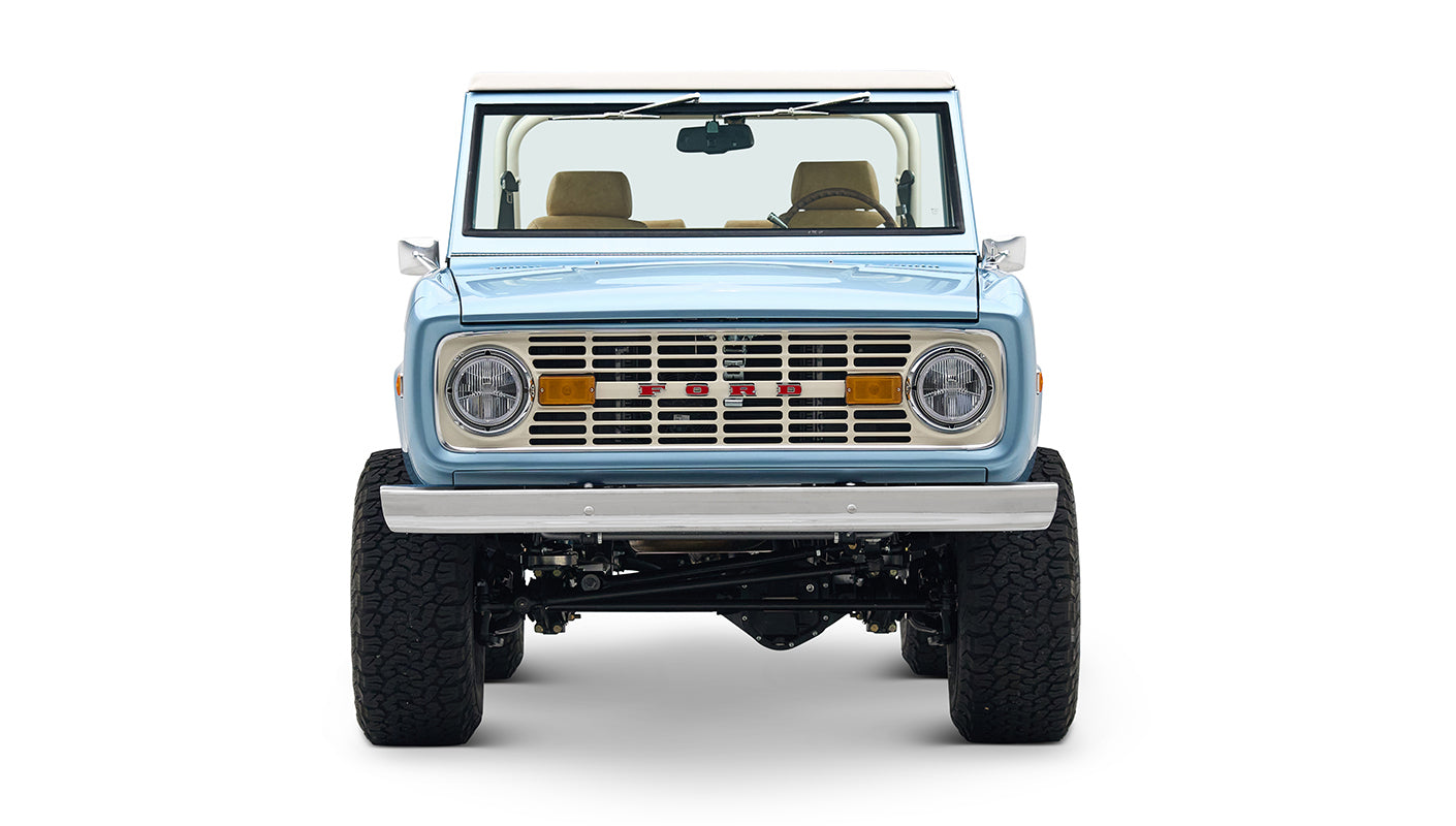 Front view of light blue Classic Ford Bronco with round headlights and FORD grille