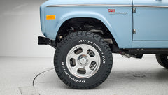 Close-up of front left wheel and front fender badge reading Classic Ford Bronco